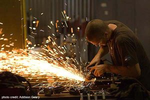 Chris Wheeler grinding metal at Bernard Katz Glass