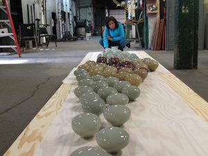 katie katz inspecting wall sculpture glass forms