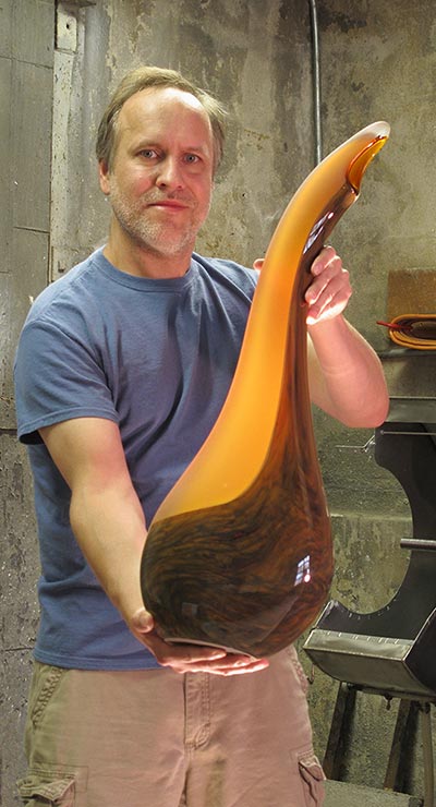 Bernard Katz holding a Salinas glass sculpture in cinnamon color - size perception